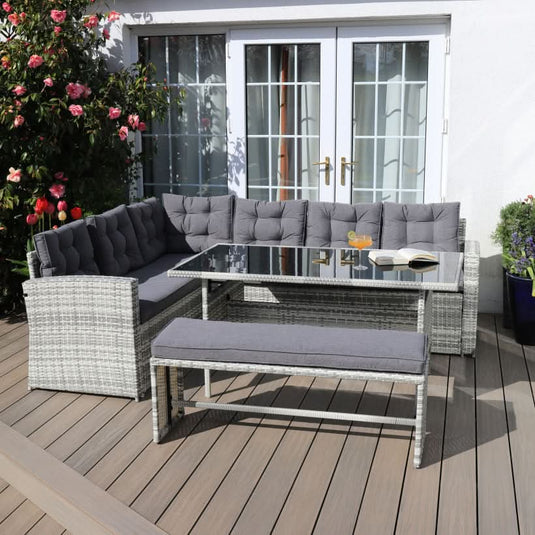 light grey corner sofa set with dark grey cushions, a glass topped rectangular table and 1 bench