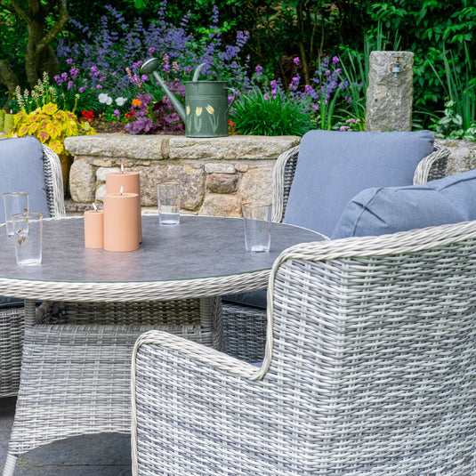 light grey 4 seater deluxe dining set with dark grey cushions and a round table