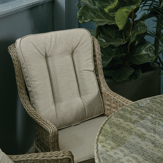 armchair in a natural colour with sand coloured back and base cushions